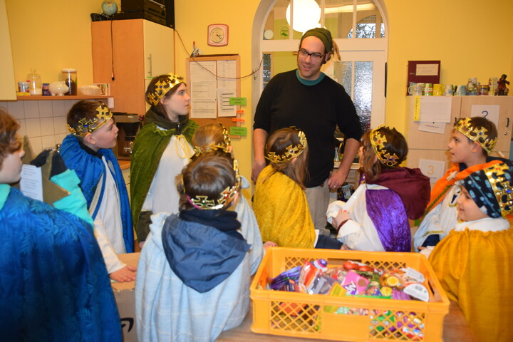 Kinder verkleidet als Sternsinger mit Mitarbeiter der Wärmestube